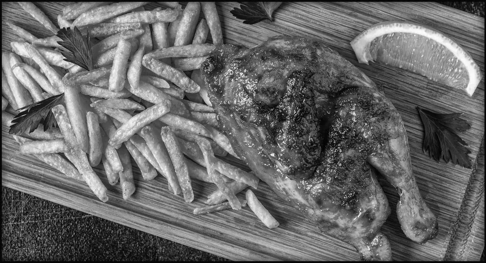 Flame-grilled peri peri chicken quarter with fries and lemon